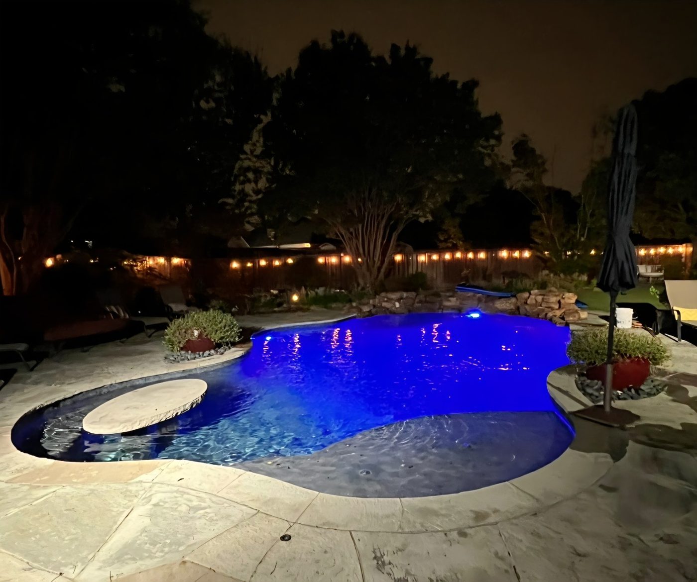 Backyard pool with blue LED lighting