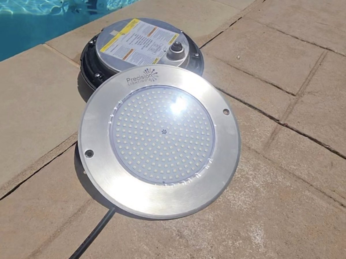 Precision Lighting LED pool-light replacement fixture beside a swimming pool